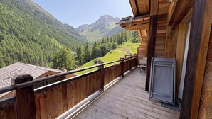 Un balcone in legno con vista su un paesaggio montuoso.