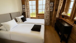 A bedroom with two beds, a desk, and a window with curtains. - Luxury chalet for 10 to 12 people with breathtaking views over the valley: 1 double bedroom with bat (Grimentz)