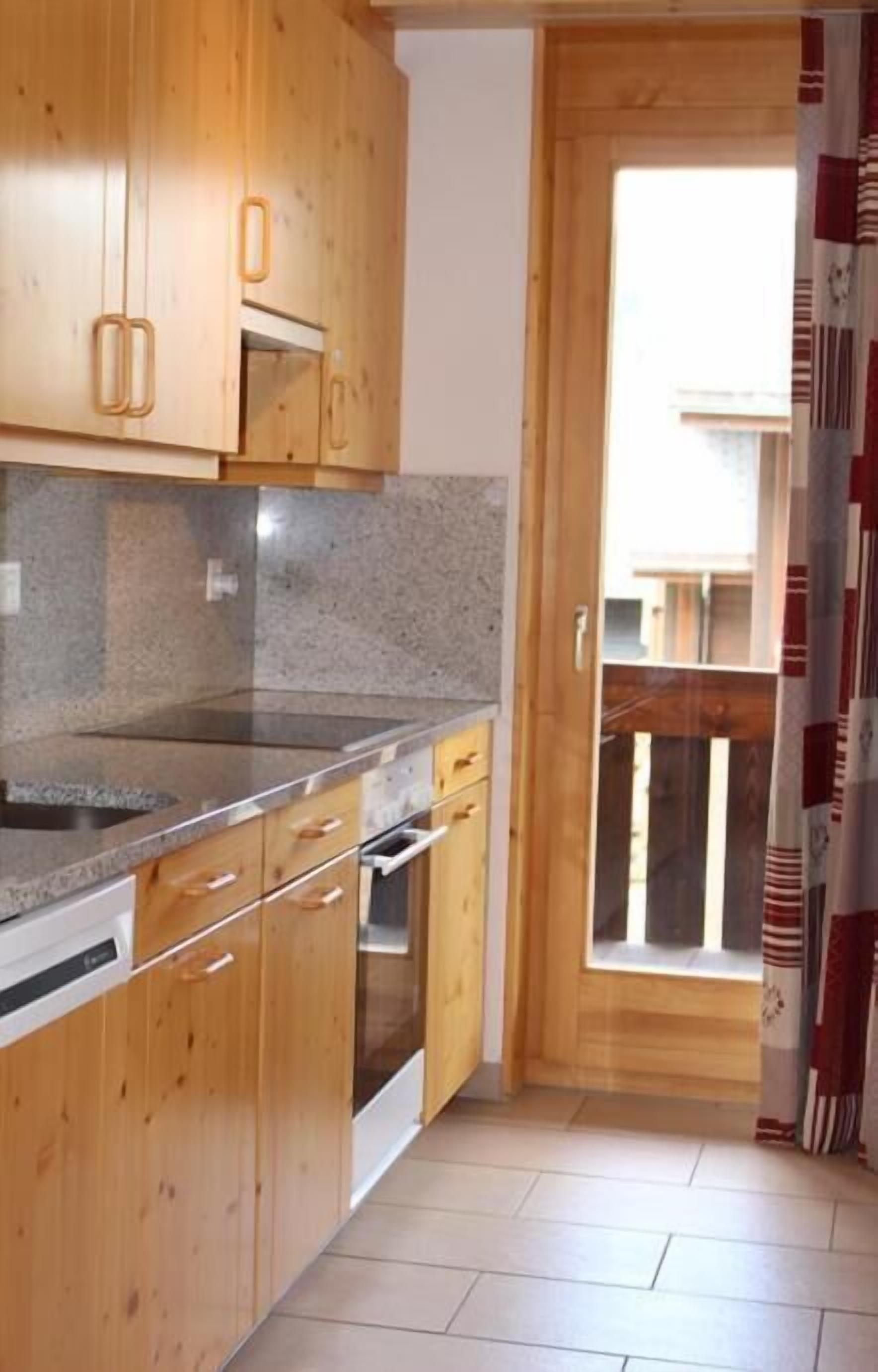 A kitchen with wooden cabinets, granite countertops, and a built-in oven.