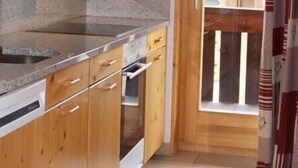 A kitchen with wooden cabinets, granite countertops, and a built-in oven. - 3-room apartment for 6 persons : living room - kitchen with dishwasher and microwave - 1 room with 1 (Grimentz)