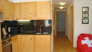 Una cucina con mobili in legno, un piano di lavoro nero e un lavello in acciaio inossidabile.