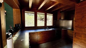 Een moderne keuken met houten kastjes, een roestvrijstalen aanrechtblad en een groot raam voor natuurlijk licht.