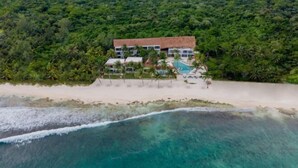 A beachfront hotel with a pool and a beach area, surrounded by dense tropical vegetation. - The Beachfront by The Fives Hotels Á la Carte - Adults Only (Playa del Carmen)