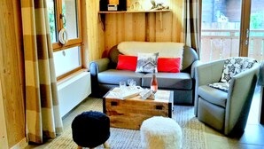 Una sala de estar acogedora con un sofá, sillones, una mesa de centro y una chimenea.