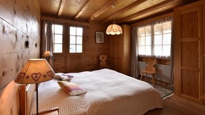 A wooden cabin room with a bed, a lamp, and a chair. - Comfortable chalet for 5 persons : Living room with fireplace - kitchen with dishwasher, microwave a (Grimentz)