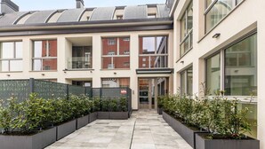 A modern building with a courtyard featuring planters and a pathway. - VivimiHome - Navigli Design Loft con Terrazzo (Milano)
