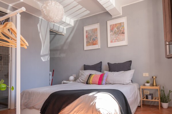 Ein Schlafzimmer mit einem Bett, einem Nachttisch, einem Wandregal und einem Deckenventilator.