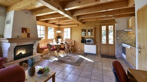 Een houten cabin met een eethoek, keuken en open haard.