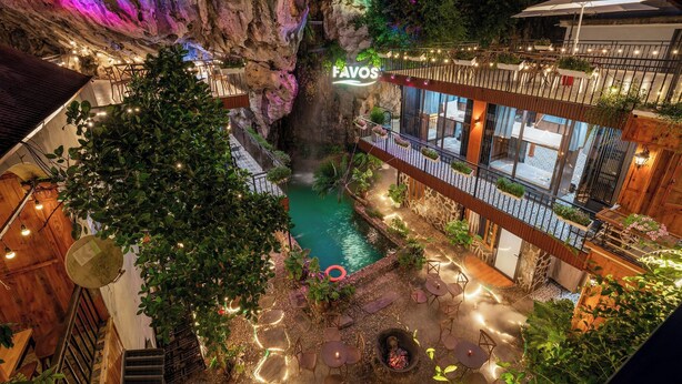 A hotel with a pool in a cave-like setting, a balcony with outdoor seating, and a sign that reads "FAVOS". - Favos Ninh Binh Hotel & Villas (Nam Hoa Lu)