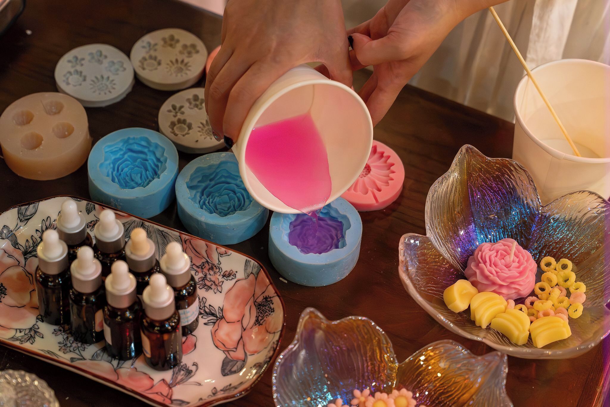 A person pouring pink liquid into a mold.