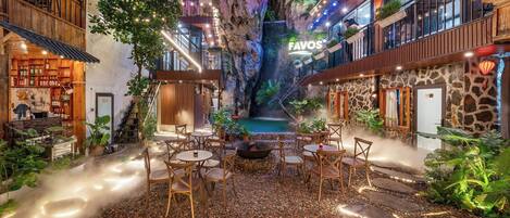 Um átrio interno com uma cascata, áreas de estar e um bar.