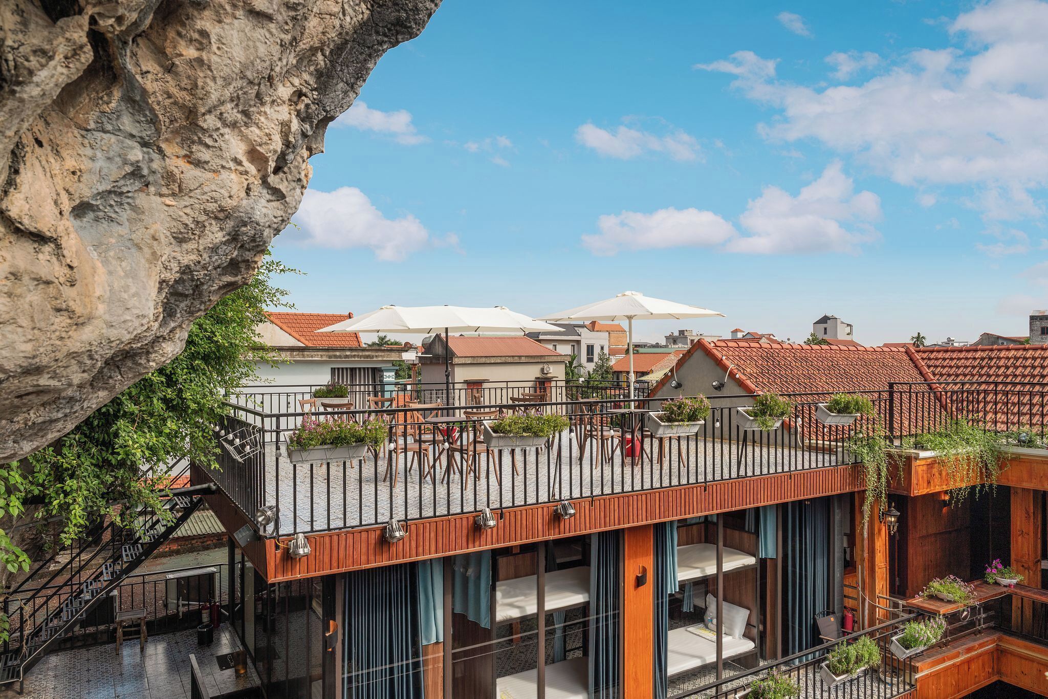 A multi-level outdoor terrace with seating areas, a staircase, and a view of the surrounding buildings.