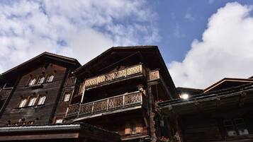 Un bâtiment traditionnel en bois, doté de nombreux balcons, sous un ciel dégagé.