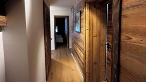 Ein Flur mit Holzvertäfelung und einer Tür zu einem Schlafzimmer.