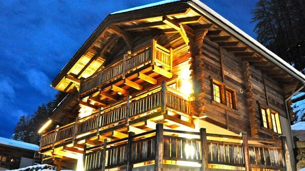 A log cabin with a balcony and multiple windows, surrounded by snow. - Chalet Jean - Grimentz - Beautiful traditional Swiss chalet for 2 to 12 people<br>Luxury 3-storey chal (Grimentz)