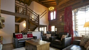 A rustic interior with a wooden staircase, leather sofas, and a chandelier. - Chalet Jean - Grimentz - Beautiful traditional Swiss chalet for 2 to 12 people<br>Luxury 3-storey chal (Grimentz)