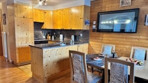 Una cocina moderna con armarios de madera, una isla central y una zona de comedor con cuatro sillas.