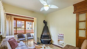 A cozy living room with a fireplace, a sofa, and a dining area. - 1-br Apartment w Fireplace in Gramado-rs Dva0103 (Gramado)