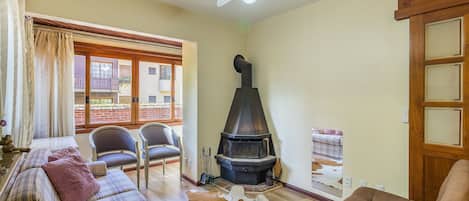 Una sala de estar acogedora con chimenea, un sofá y un comedor.