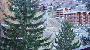 A mountainous area with wooden lodges and a ski lift. - 2-room apartment for 4 persons : Living room with 2 sofa-beds - 1 room with 2 beds - kitchen with fi (Grimentz)