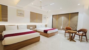 Quarto de hotel com duas camas, uma escrivaninha e uma cadeira.