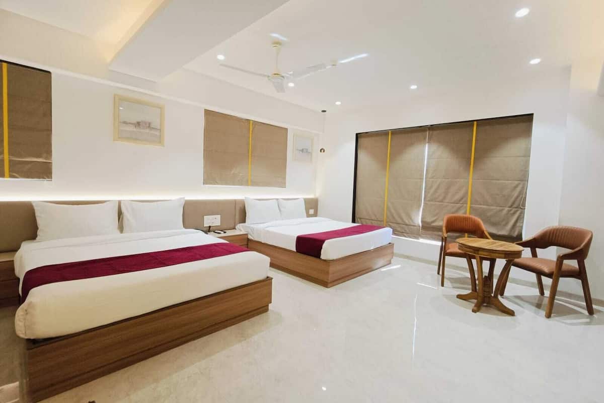Una habitación de hotel con dos camas, un escritorio y una silla.