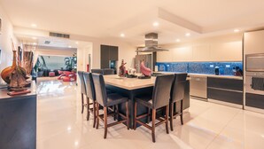 A modern kitchen with a central island, stainless steel appliances, and a view to the outside. - Townhouse With Ocean View Puerto Bahia P5 (Las Terrenas)