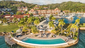 A resort with a large pool, palm trees, and a marina. - Townhouse With Ocean View Puerto Bahia P5 (Las Terrenas)