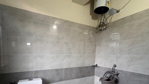 A bathroom with a toilet, a shower, and a sink. - Lahaven Guest House (Shillong)