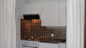 A kitchen with a stove, oven, and a backsplash with circular patterns. - Studio-apartment for 2-3 persons : Living room with 2 sofa-beds and 1 pull-out bed - kitchenette wit (Grimentz)