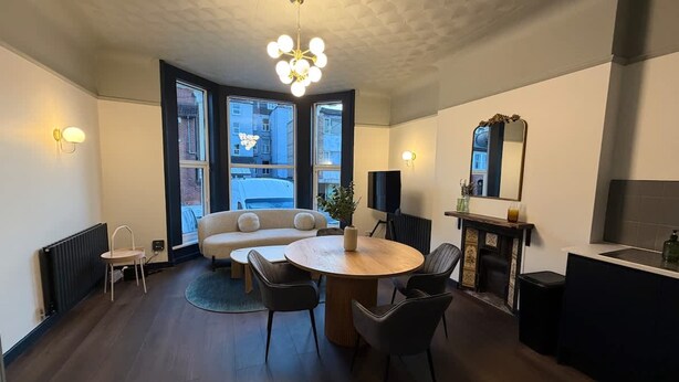 A modern kitchen with a dining area, large windows, and a chandelier. - Luxury 2 5 Bedroom Flat in Southsea (Portsmouth)