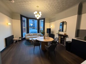 A modern kitchen with a dining area, large windows, and a chandelier. - Luxury 2 5 Bedroom Flat in Southsea (Portsmouth)