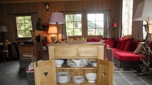 A rustic wooden room with a central wooden cabinet displaying plates and bowls. - Very comfortable chalet for 6-8 persons : Living room with fireplace - kitchen with dishwasher, Dolc (Grimentz)