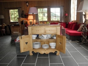 Ein rustikaler Holzraum mit einem zentralen Holzschrank, der Teller und Schüsseln präsentiert.