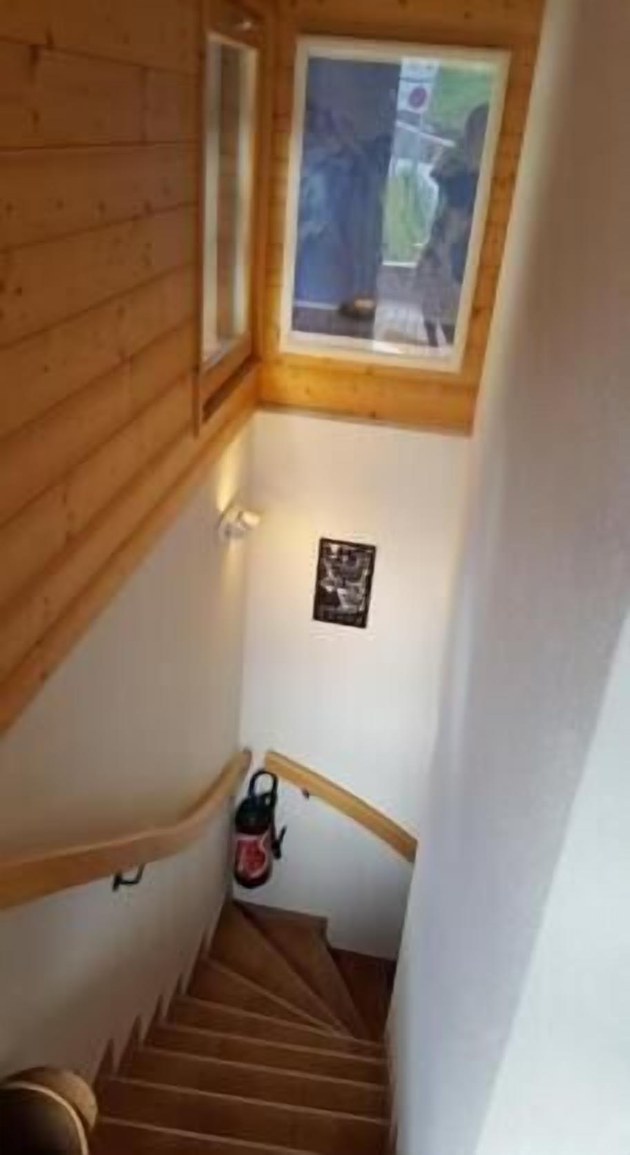 A wooden staircase with a small window at the top.