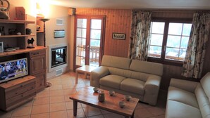 A living room with a fireplace, a sofa, a television, and a coffee table. - Very comfortable 4 room apartment for 6-7 persons : Living room with fireplace - kitchen with dishwa (Grimentz)
