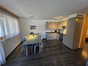 A compact kitchen with a dining table, chairs, a microwave, and a coffee maker. - Very comfortable 4 room apartment for 6 persons : Living room with fire-place - kitchen with dishwas (Grimentz)