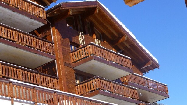 Ein mehrstöckiges Holzhaus mit Balkonen.