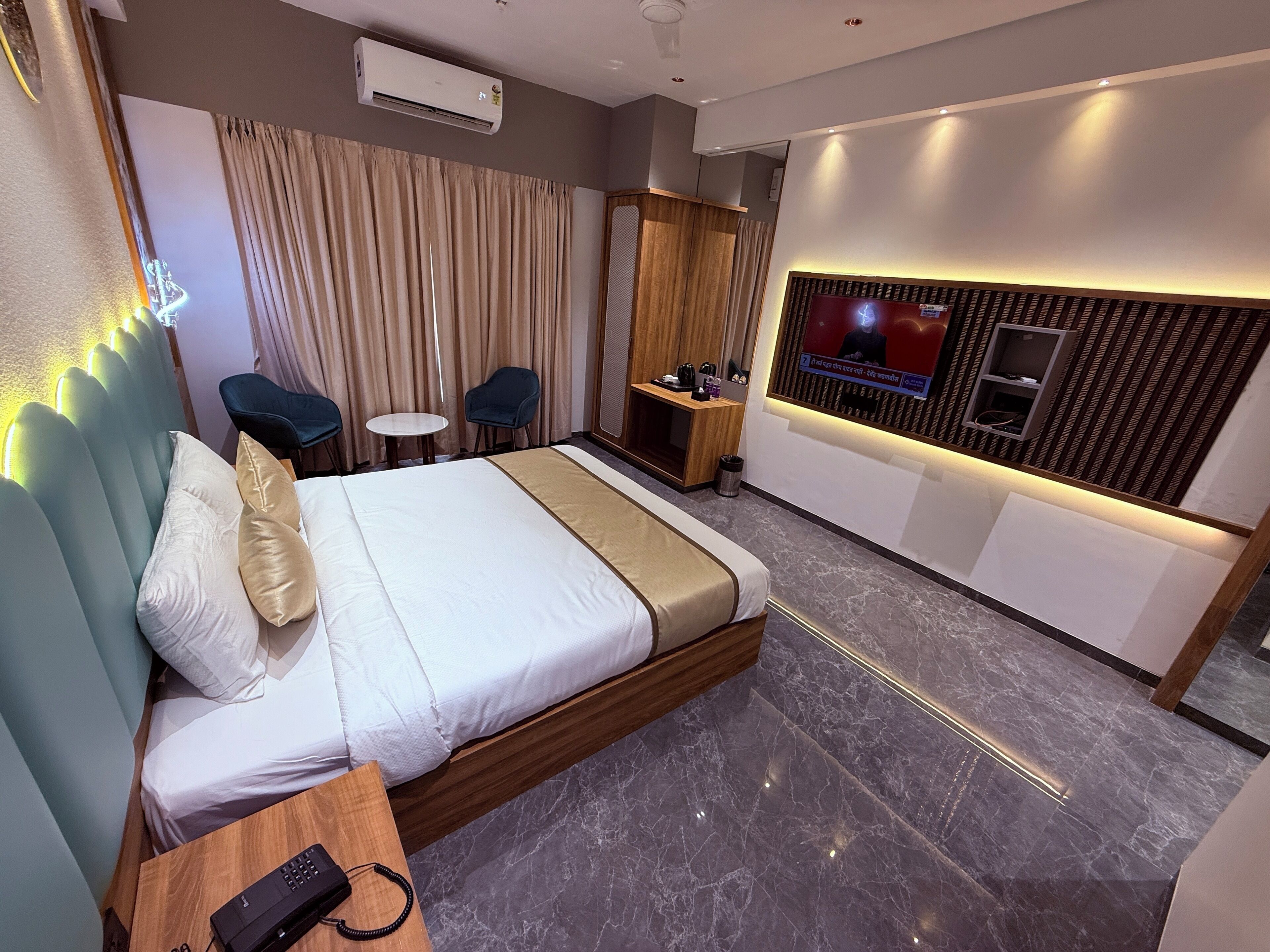 Ein modernes Hotelzimmer mit einem großen Bett, einem Schreibtisch, einem Fernseher und einer Sitzecke.