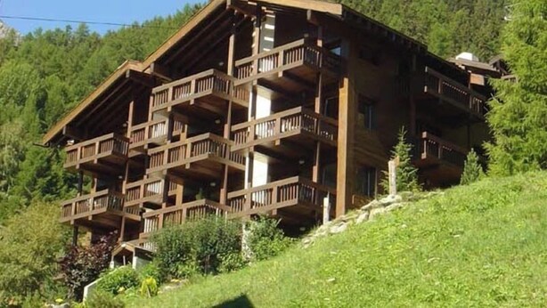 A multi-story wooden chalet with balconies, set in a mountainous area. - 2 room apartment for 2-4 persons : Living room with sofa-bed and 1 pull-down bed - kitchen with dish (Grimentz)