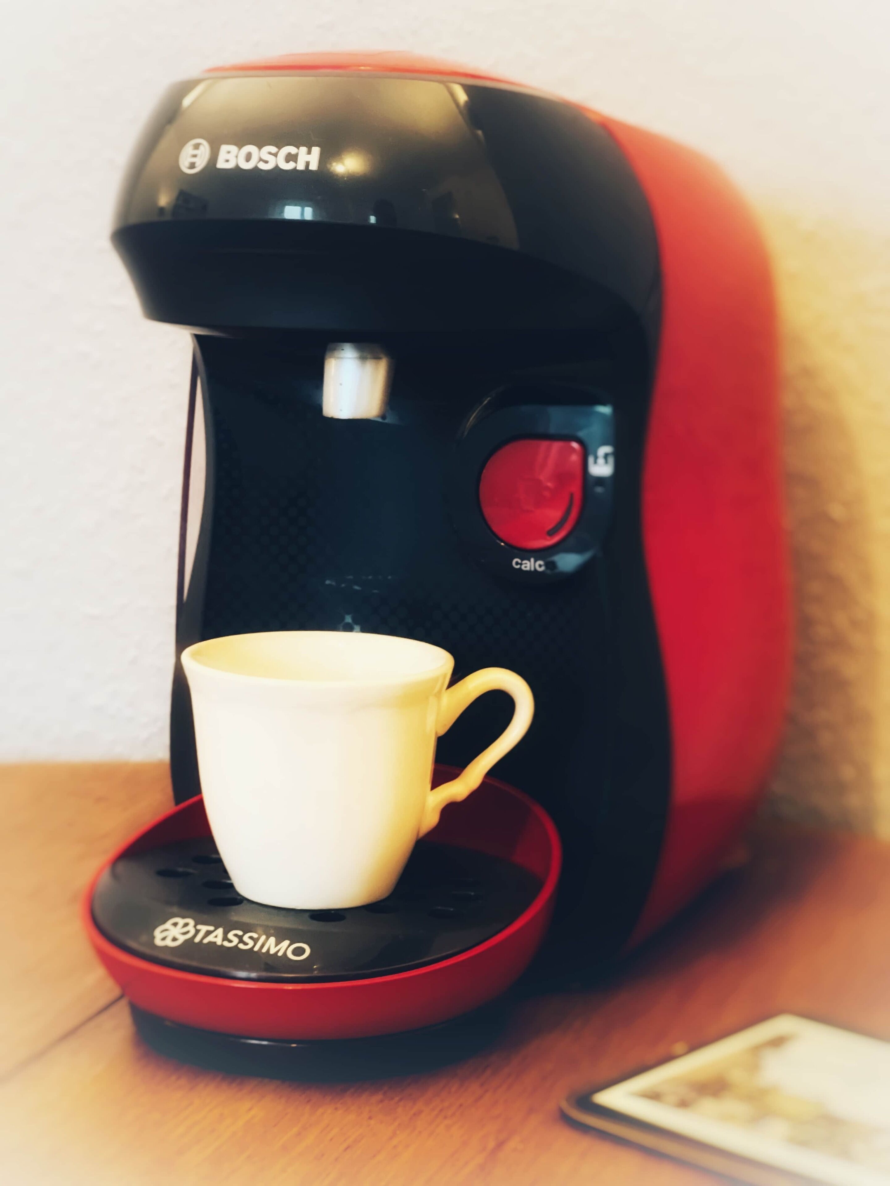 Une machine à café avec une tasse posée sur son socle.