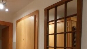 A hallway with a wooden door and a window with a grid pattern. - Comfortable 2  1/2-room apartment for 4 persons : living room - 1 alcove with 2 bunk beds - 1 room w (Grimentz)