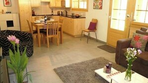 Ett kompakt bostadsutrymme med kök, matplats och sittgrupp.