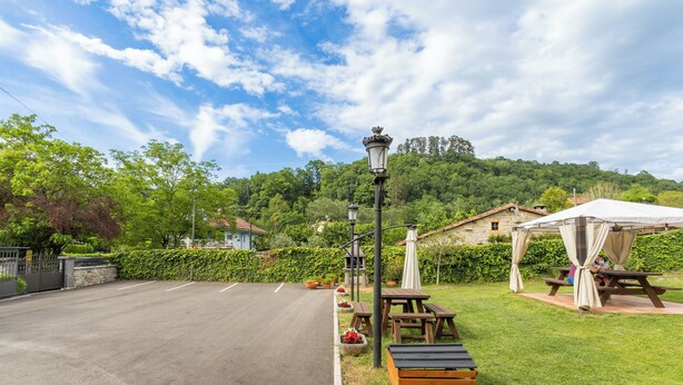 A paved road, picnic tables, a gazebo, and a lamp post in a park setting. - Apartments La Huerta de la Torre ( Apartment number 1 ) (Cangas de Onis)
