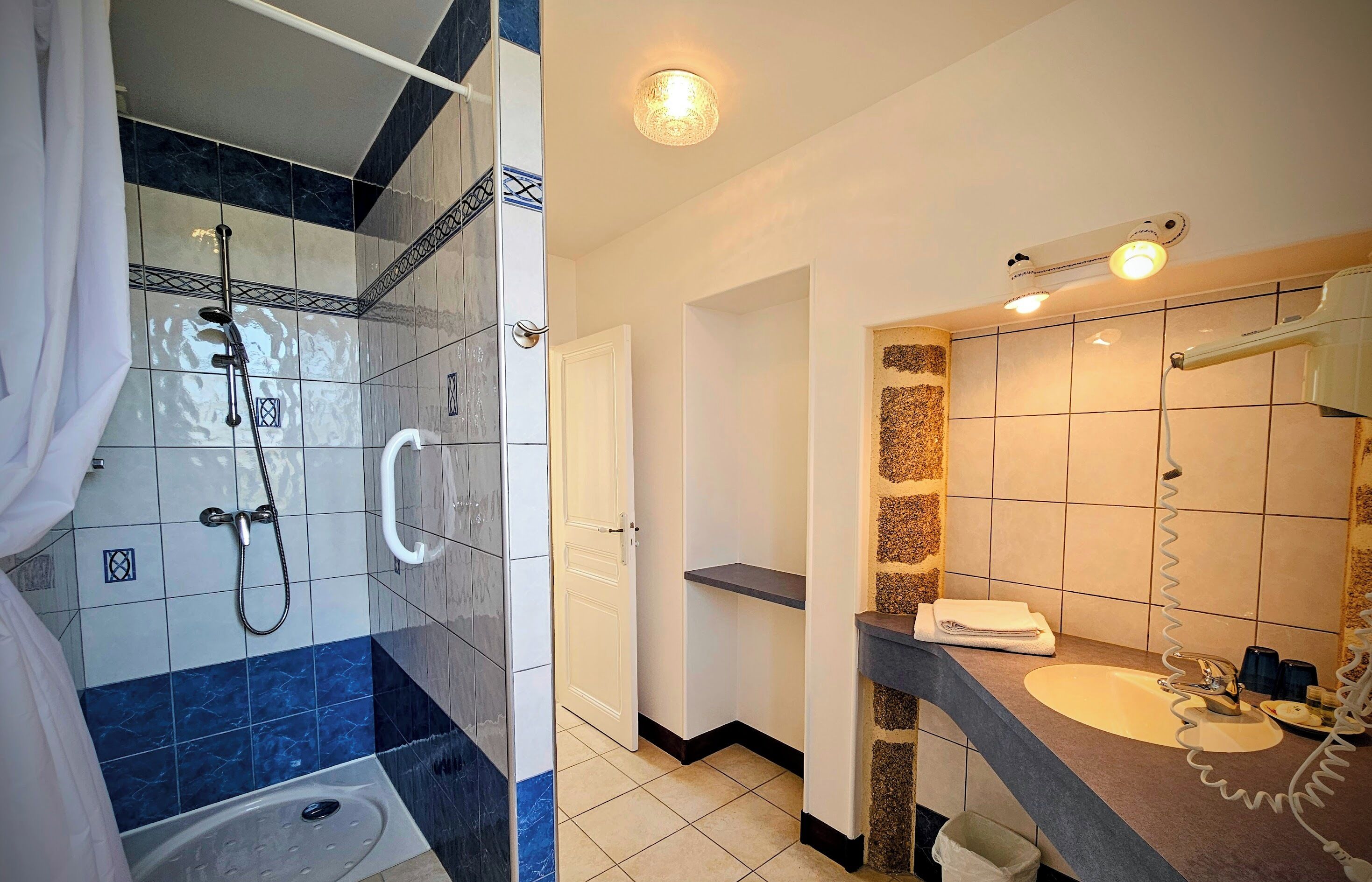 A bathroom with a shower, a sink, and a mirror.