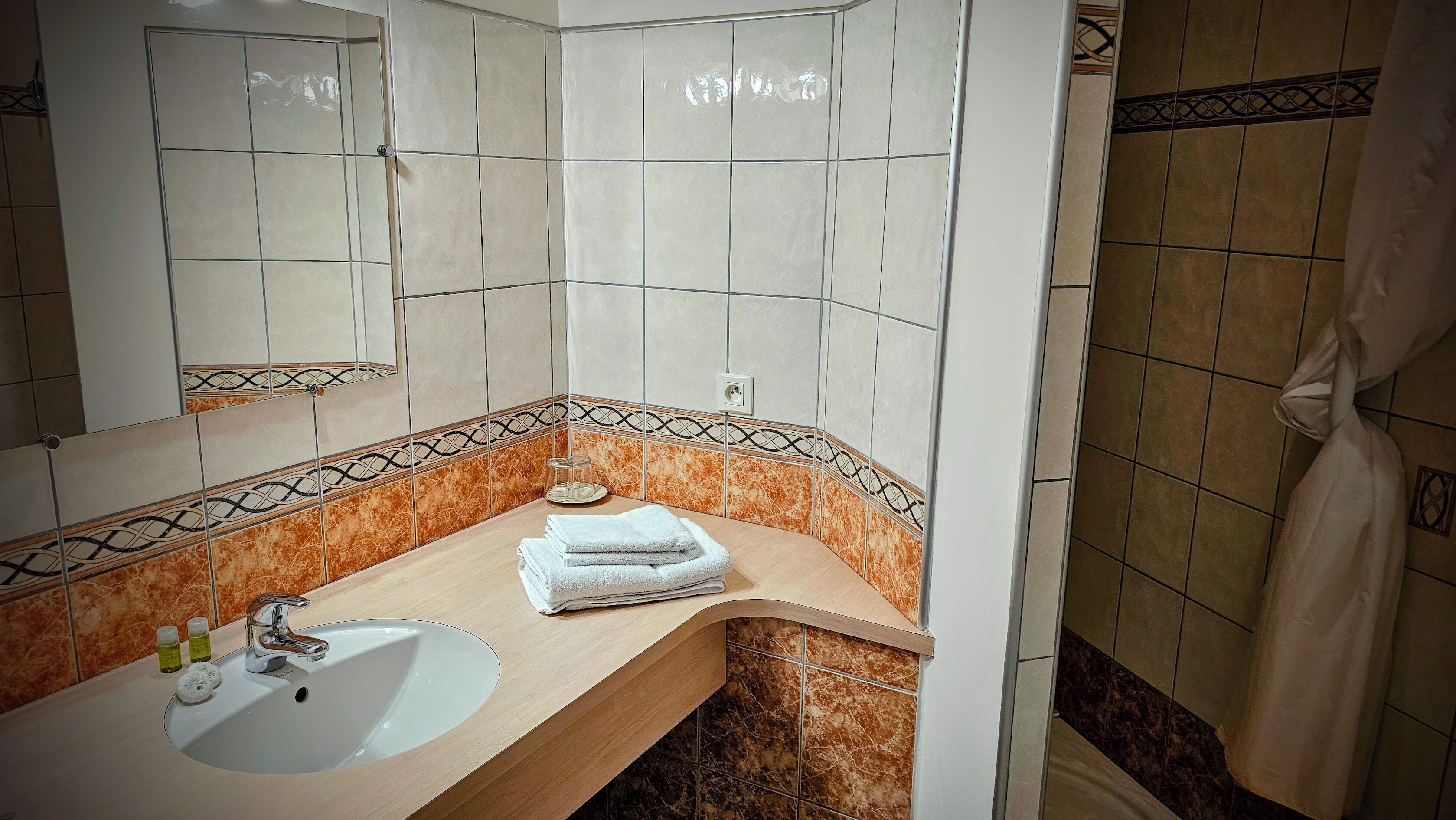 Ein Badezimmer mit Waschbecken, Spiegel und gestapelten Handtüchern.