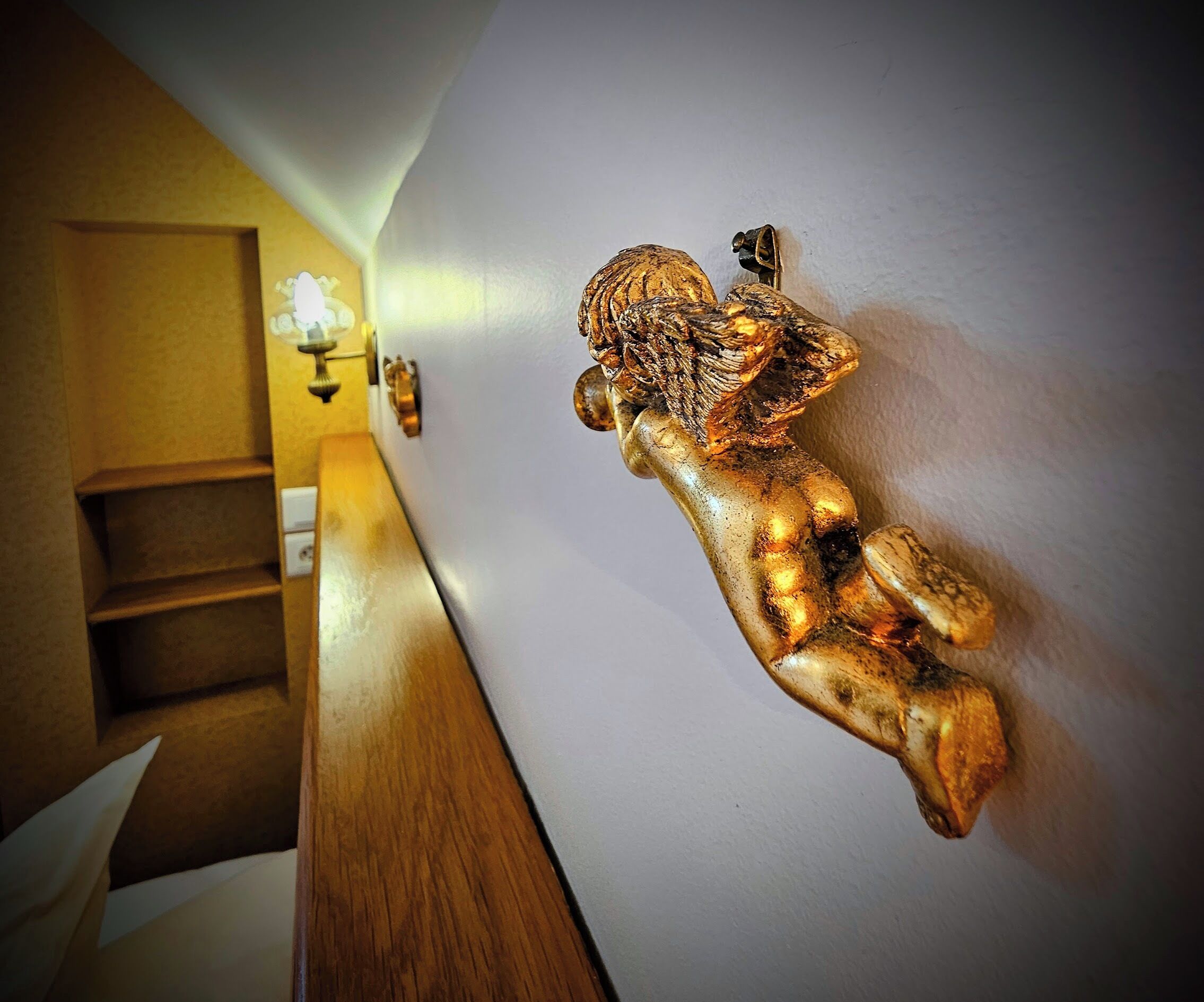 A staircase with a wall-mounted golden sculpture of a figure.
