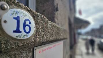 A building corner with a house number plaque '16' and a sign '689, Arrondit de Vauguillon'.