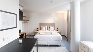 A modern hotel room with a large bed, bedside tables, a desk, and a wardrobe. - Regras Apartments & Garden A2 by Benefit Collection (Porto)