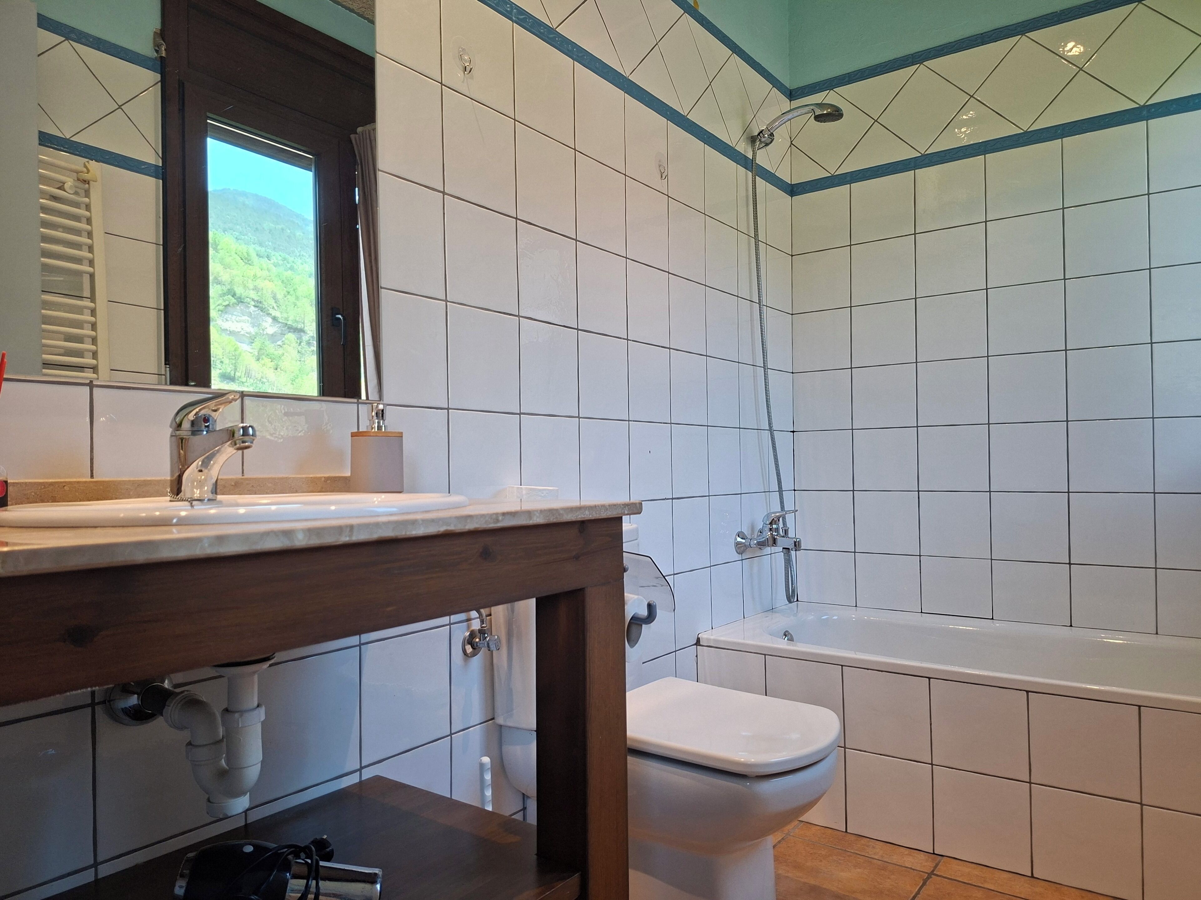 Tweepersoonskamer | Badkamer | Een haardroger, handdoeken, toiletpapier